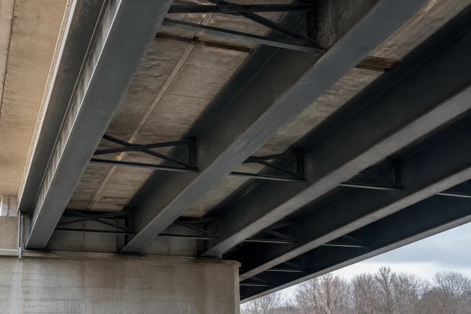 Underside of a steel girder bridge supporting a concrete deck